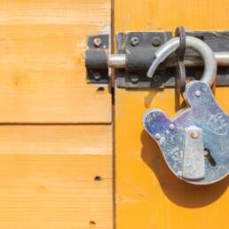 brown wooden door with padlock